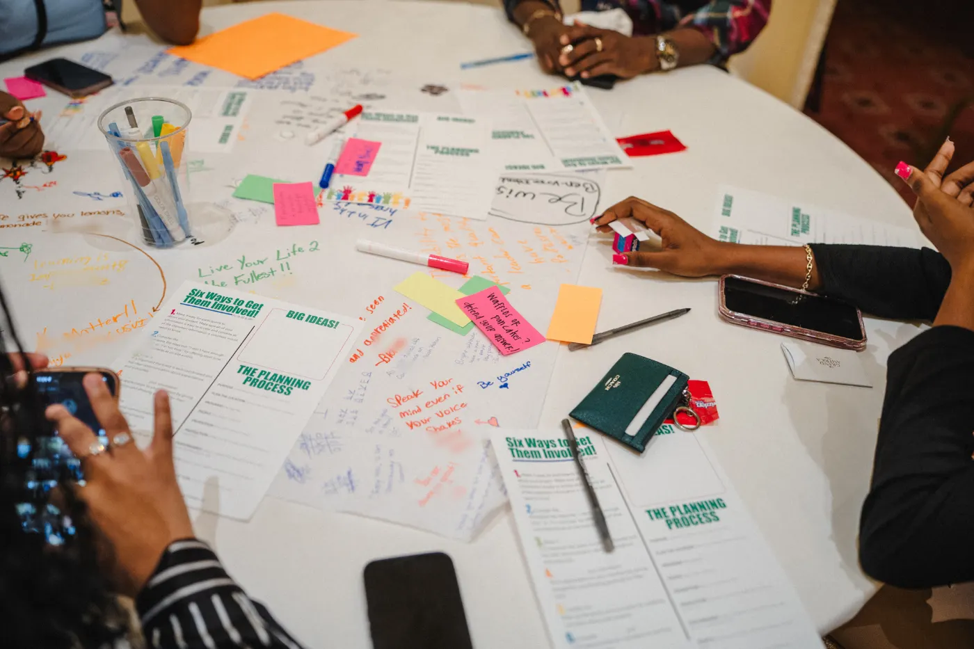 Educators reviewing learning artifacts spread across a table