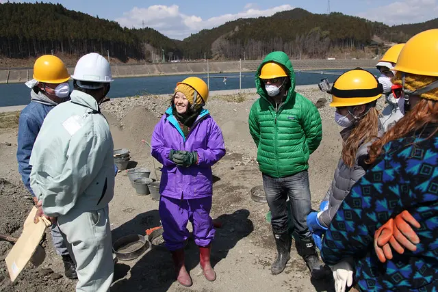 Learners in hard hats doing fieldwork with a local practitioner